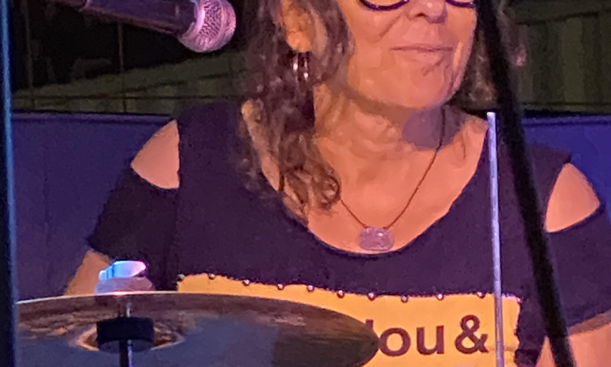 Lauren Addario playing drums with a smile