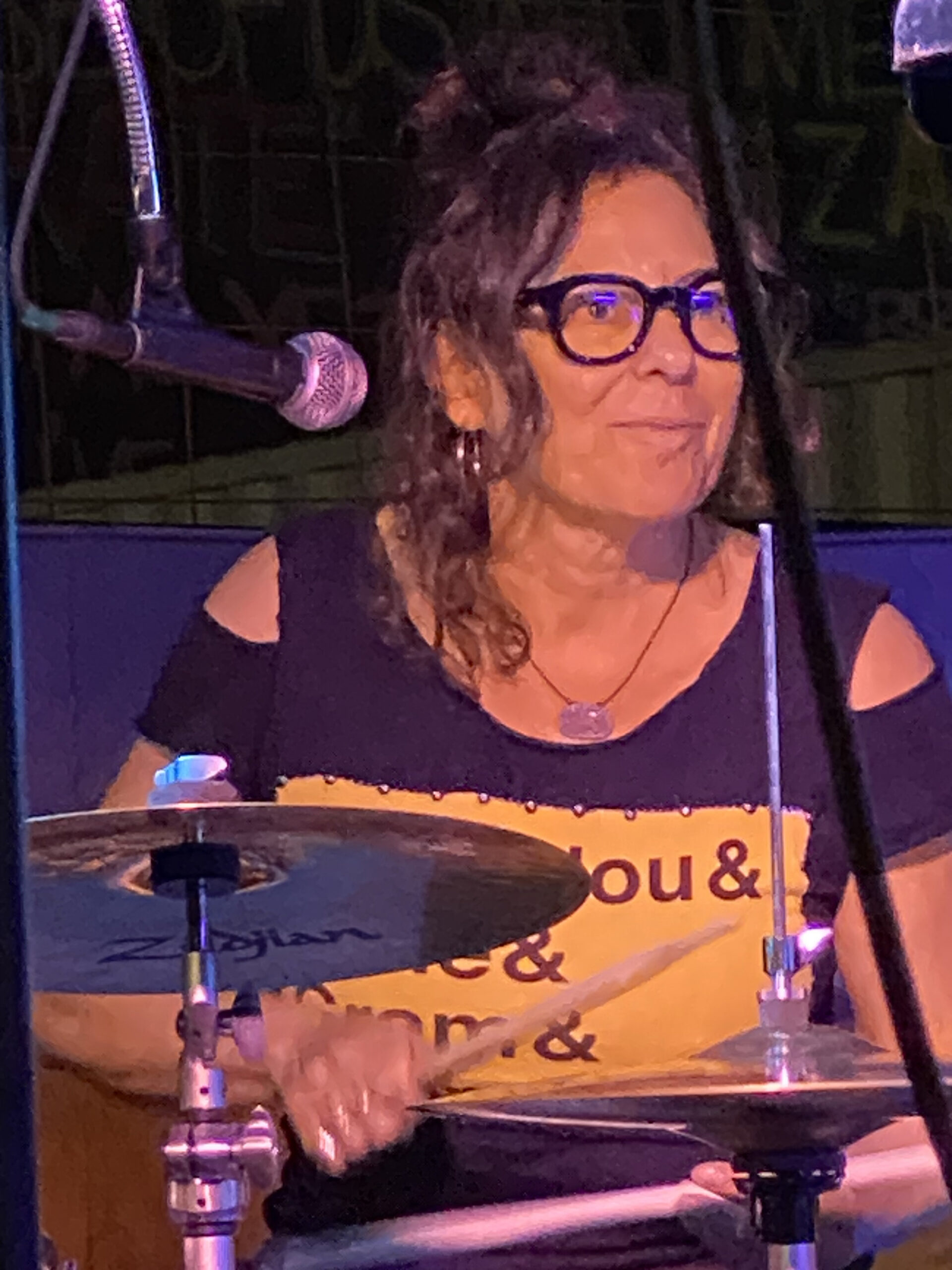 Lauren Addario playing drums with a smile