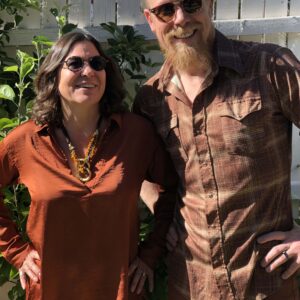 Photo of Jonathan Mack and Lauren Addario wearing rust -colored clothing and posing for a portrait. Photo by Sandra Mack