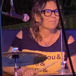 Lauren Addario playing drums with a smile